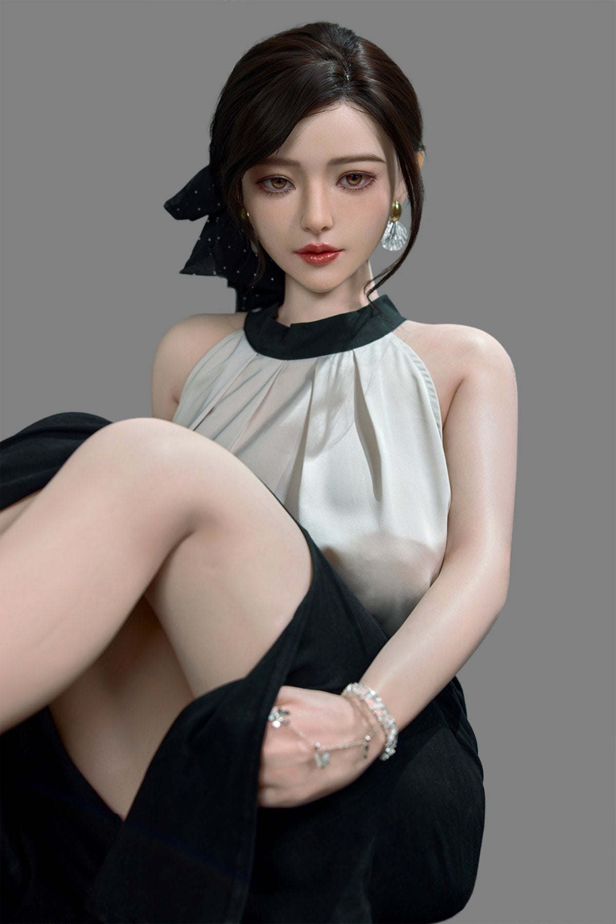 Starpery 171cm D - Asuka Eva – Seated pose on chair, cream halter top with black skirt, dark hair in half-up style, plain grey backdrop.
