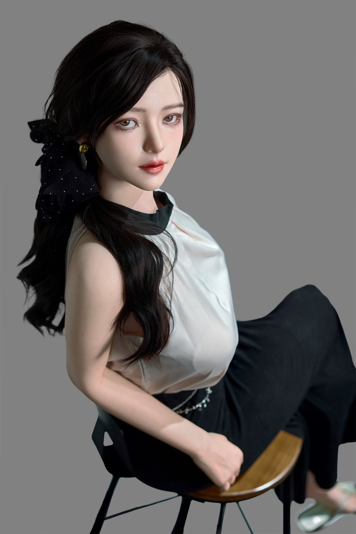 Starpery 171cm D - Asuka Eva – Seated pose on chair, cream halter top with black skirt, dark hair in half-up style, plain grey backdrop.