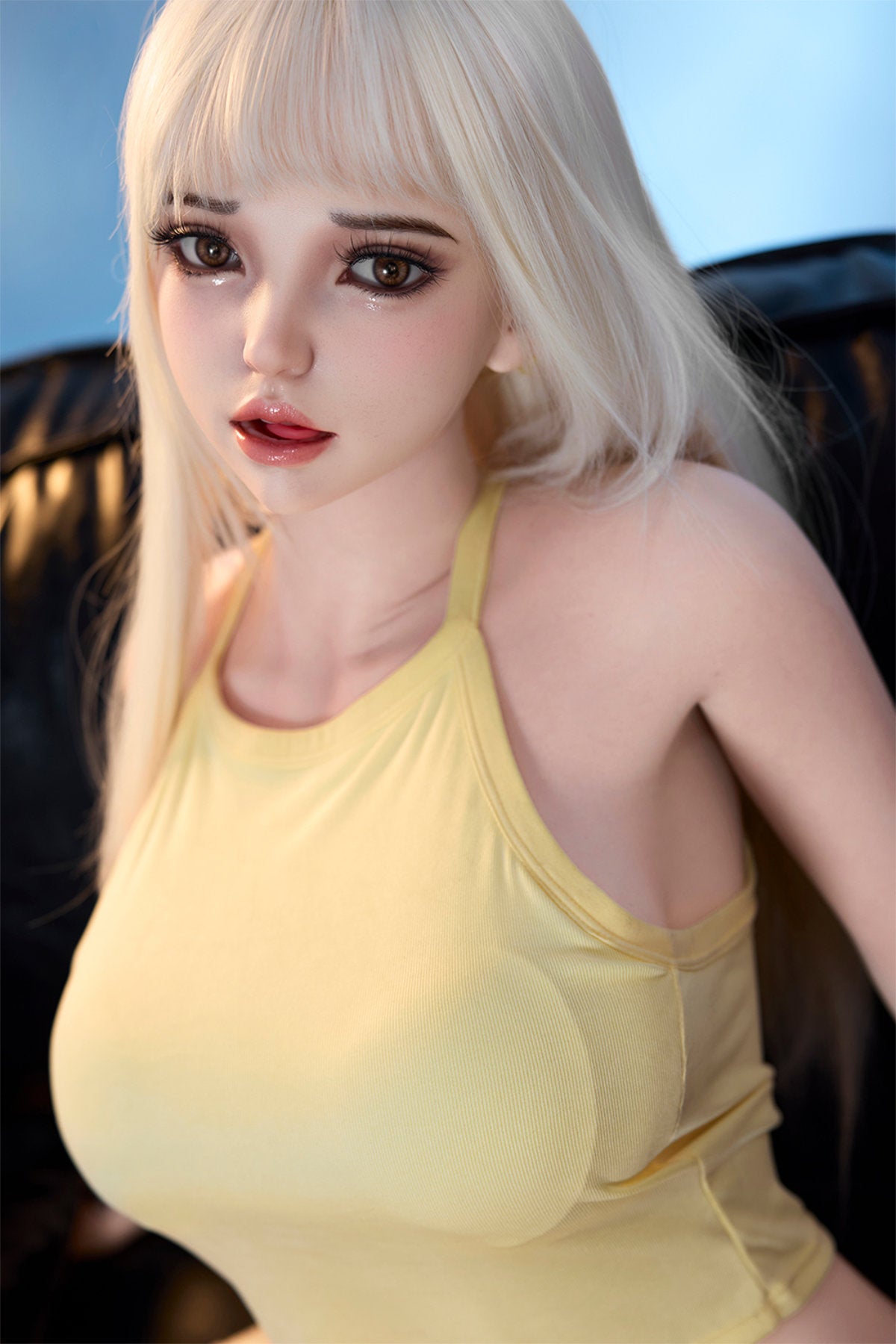 Starpery 171cm D - Seraphina – Close-up pose, pale blonde hair, yellow tank crop top, dark evening/window backdrop.