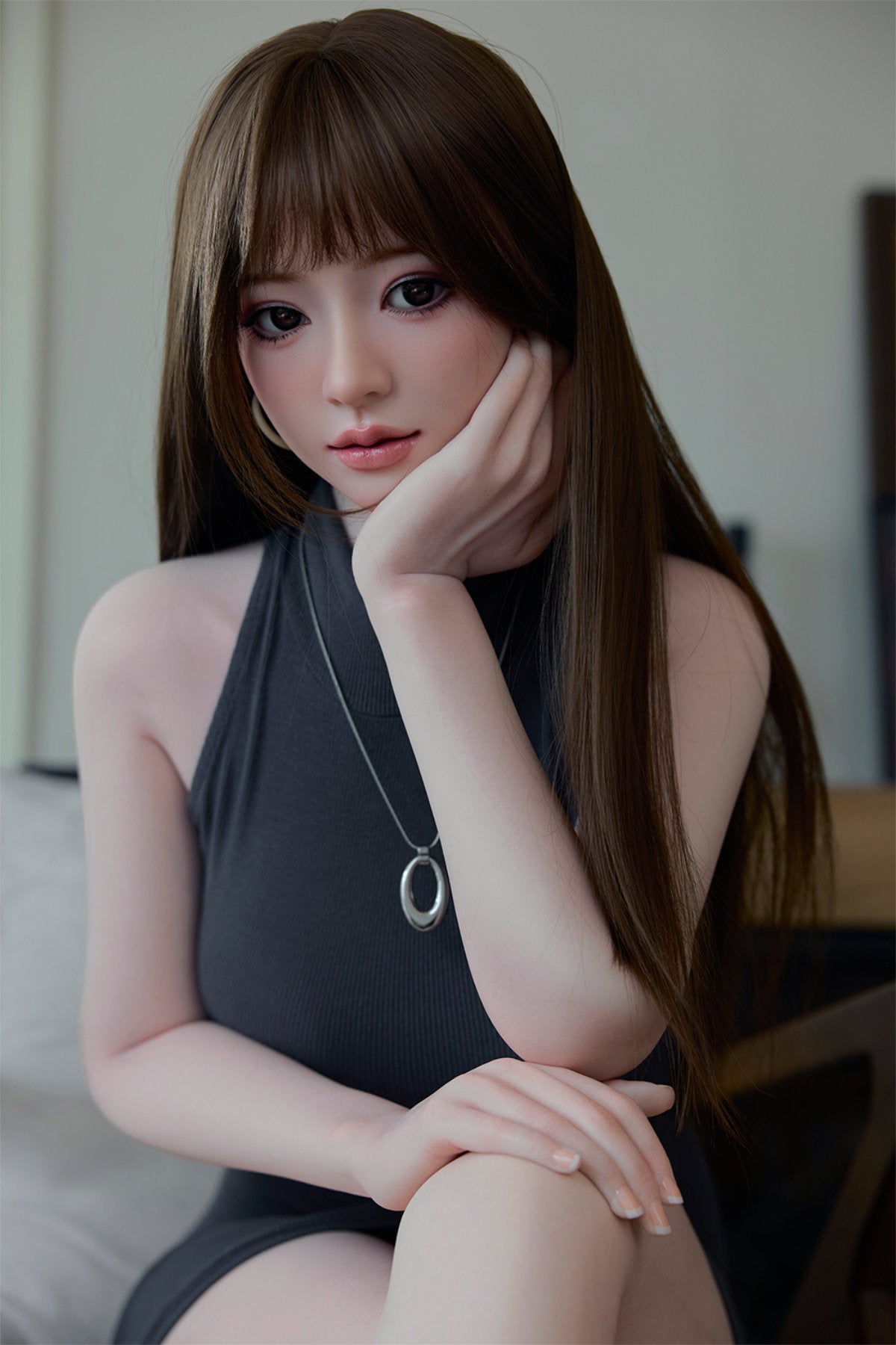 Starpery 171cm D - Snow – Seated pose, grey sleeveless top, choker necklace, brown bangs hairstyle, dark wood backdrop.