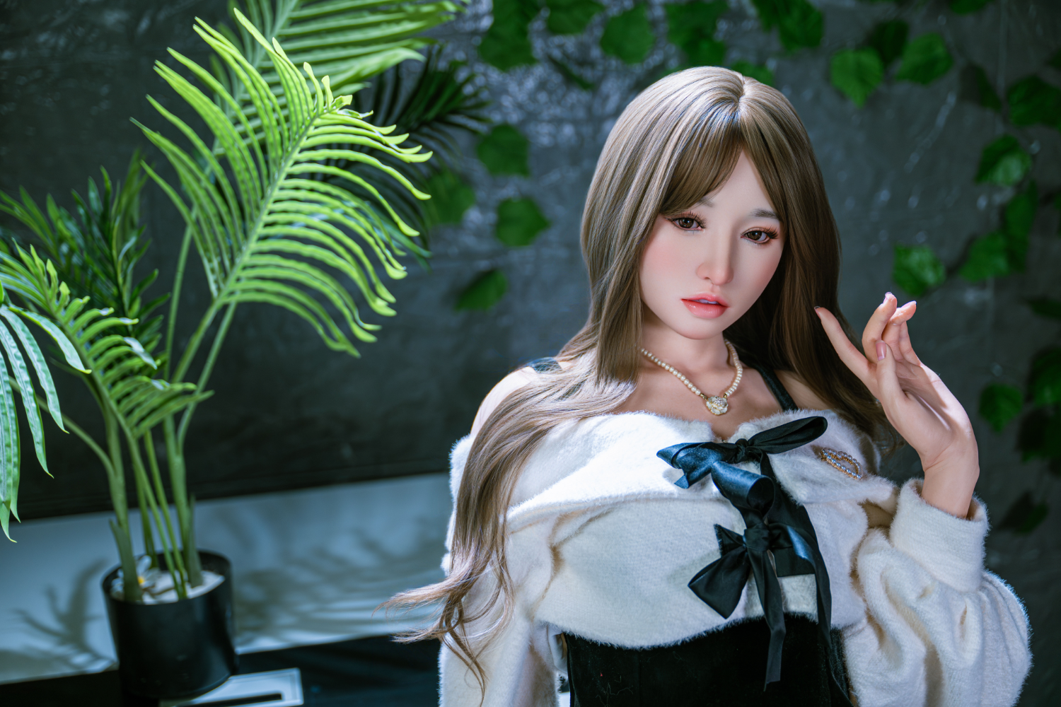 TAYU Doll 160 cm A Silicone - Angel Moe  wearing a white sweater with a black bow in a room with plants.
