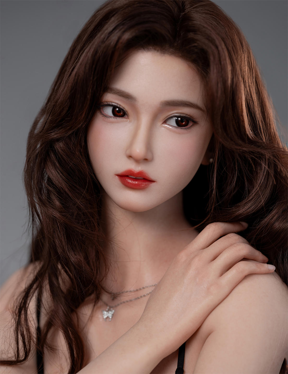TOP-CYDOLL 168cm F-Cup Rinka Realistic Sex Doll close-up beauty portrait, long wavy auburn hair, fair skin, red lipstick, pearl necklace, one hand resting near her bare shoulder, soft gray studio backdrop