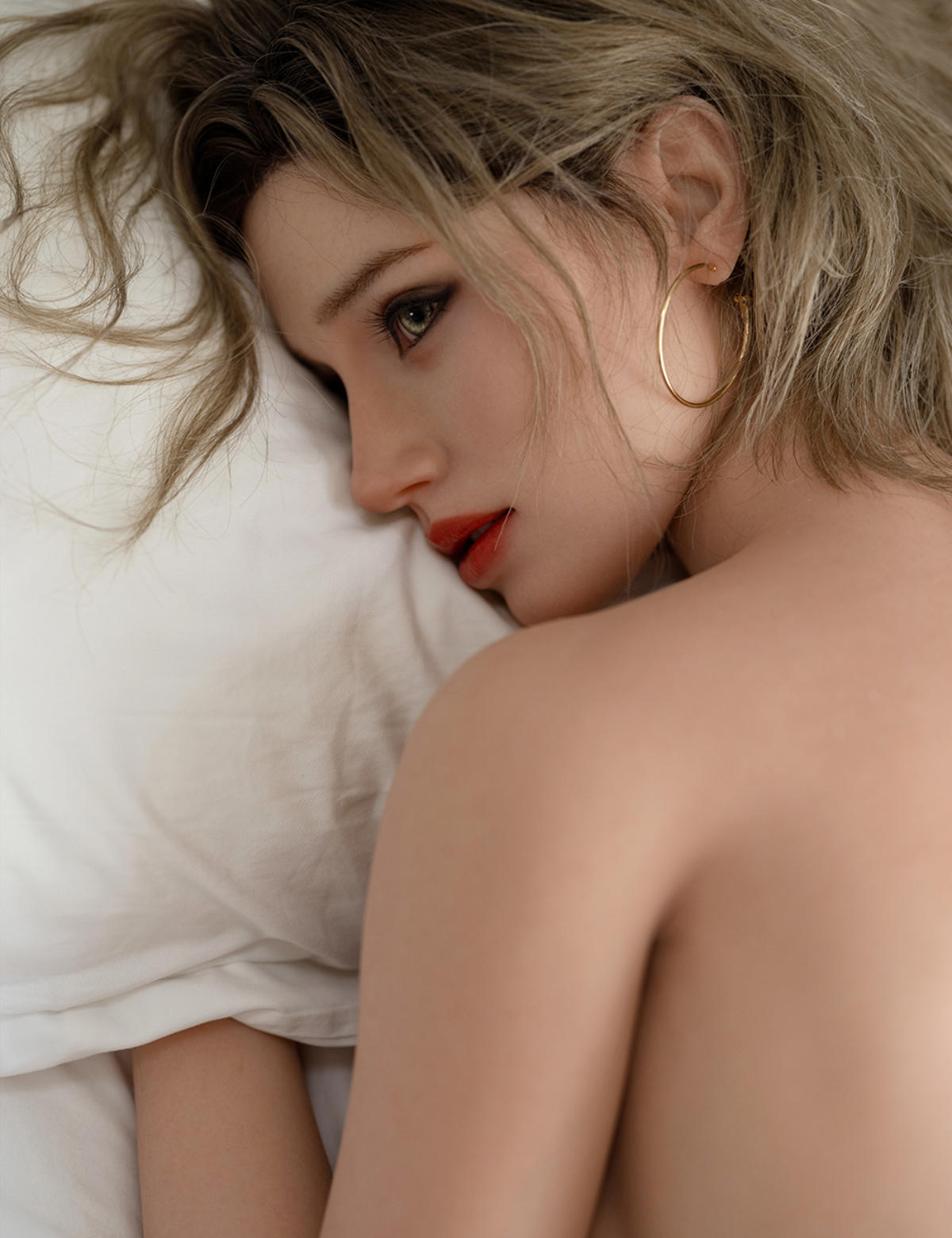Image of TOP-CYDOLL 168cm F-Cup Sofia Realistic Sex Doll lying in a bed with white sheets.