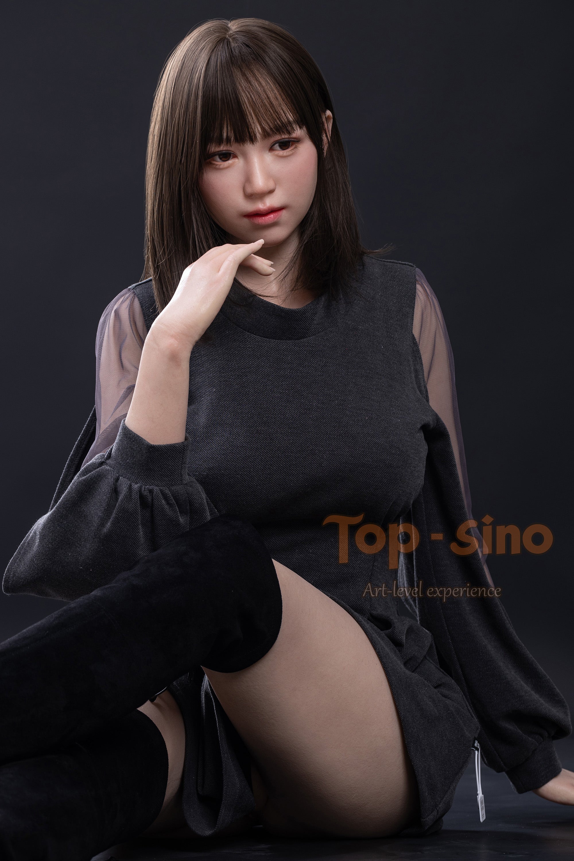 Top Sino 167 cm Platinum Silicone Recreated Series - Miju V2 (RRS+) wearing a gray outfit with sheer sleeves sitting above the table, against a dark background.