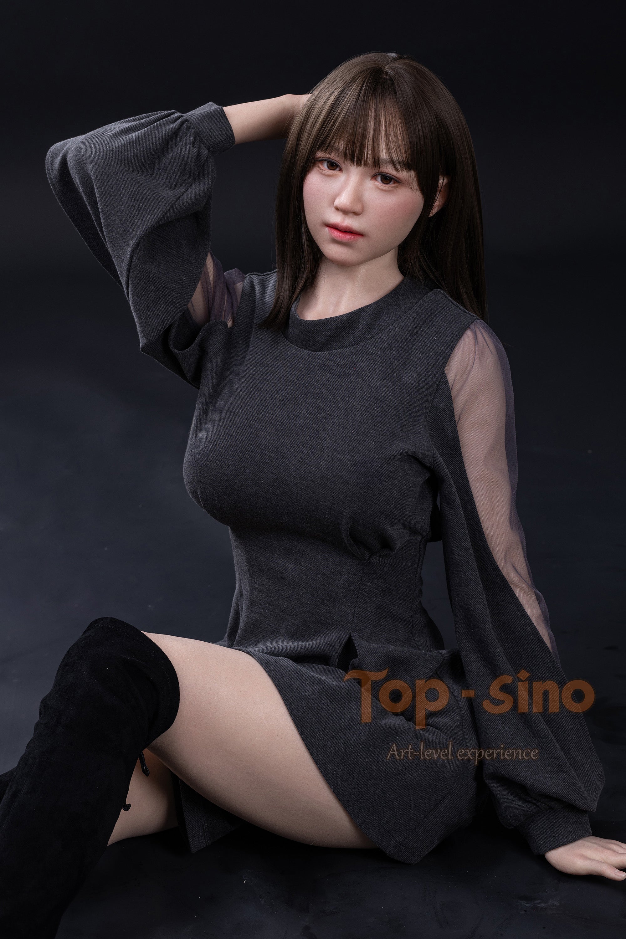 Top Sino 167 cm Platinum Silicone Recreated Series - Miju V2 (RRS+) wearing a dark gray dress with sheer sleeves sitting with leg crossing against a black background.