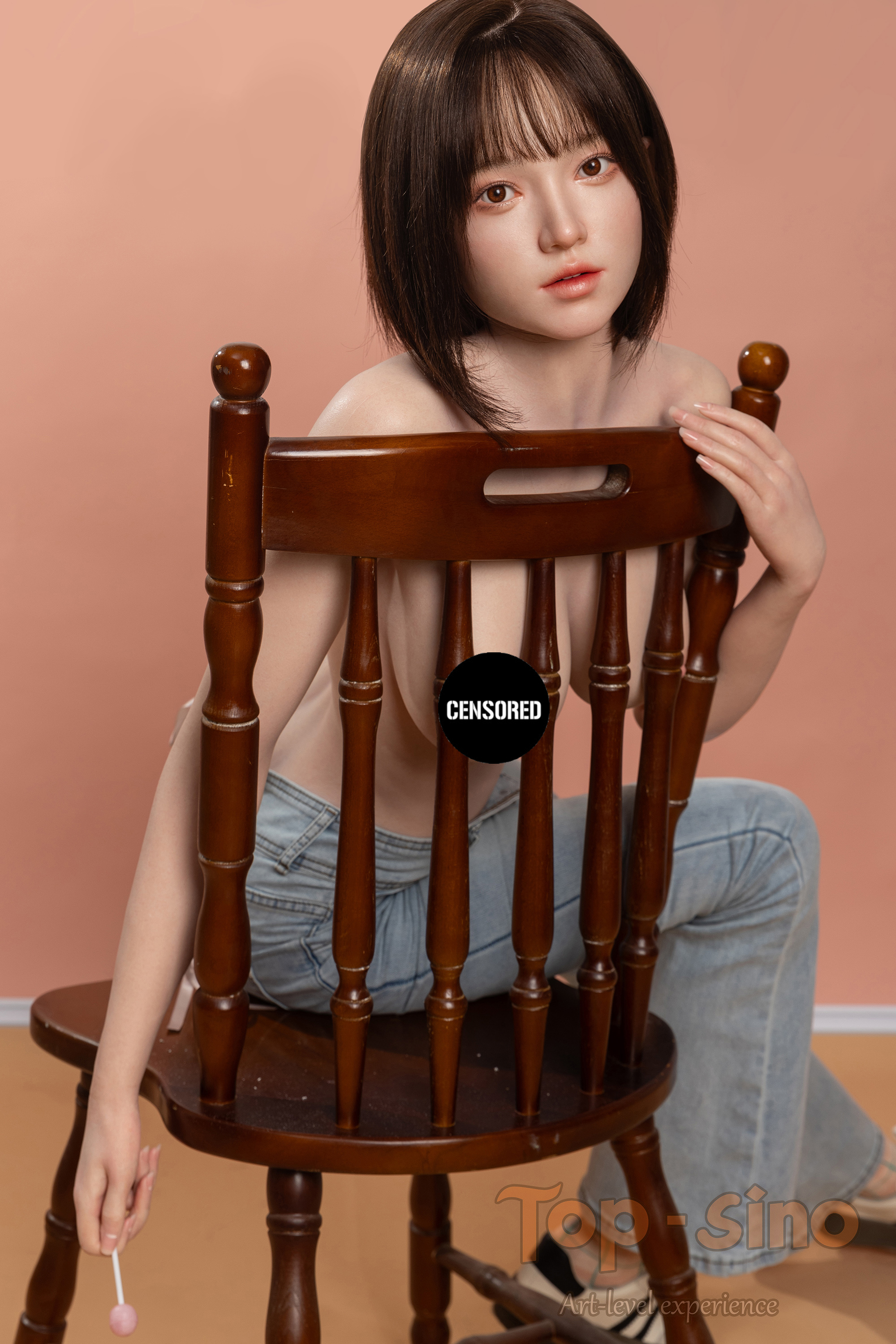 Top Sino 167 cm Platinum Silicone - Mimu (RRS+) - V2 sitting on a wooden chair wearing sexy denim shorts against a peach wall.