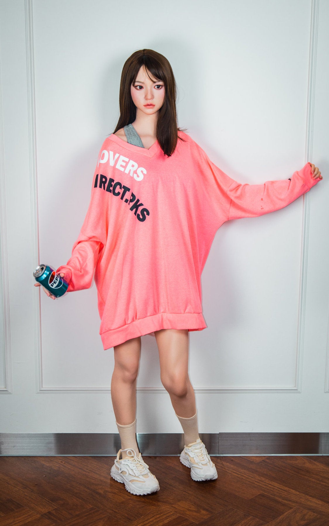 Zelex Doll K-Series 168 cm B Silicone - Somi three-quarter view in oversized pink hoodie, long dark brown hair, white studio background
