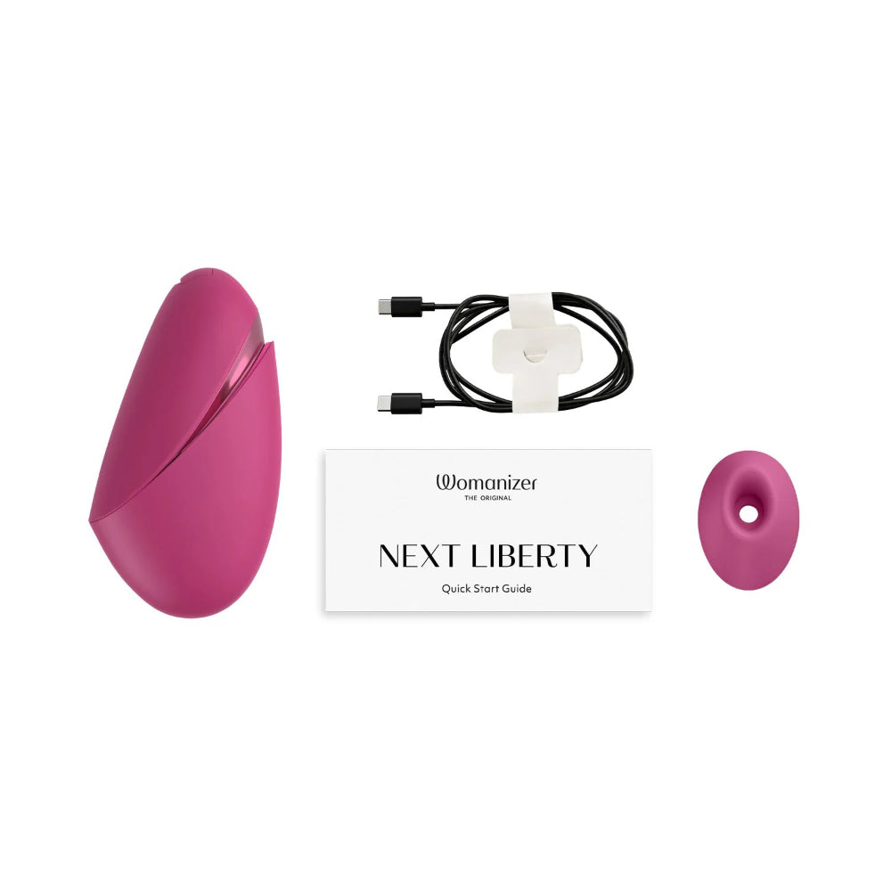 Womanizer Next Liberty with magnetic charging cable and interchangeable stimulation head accessories.