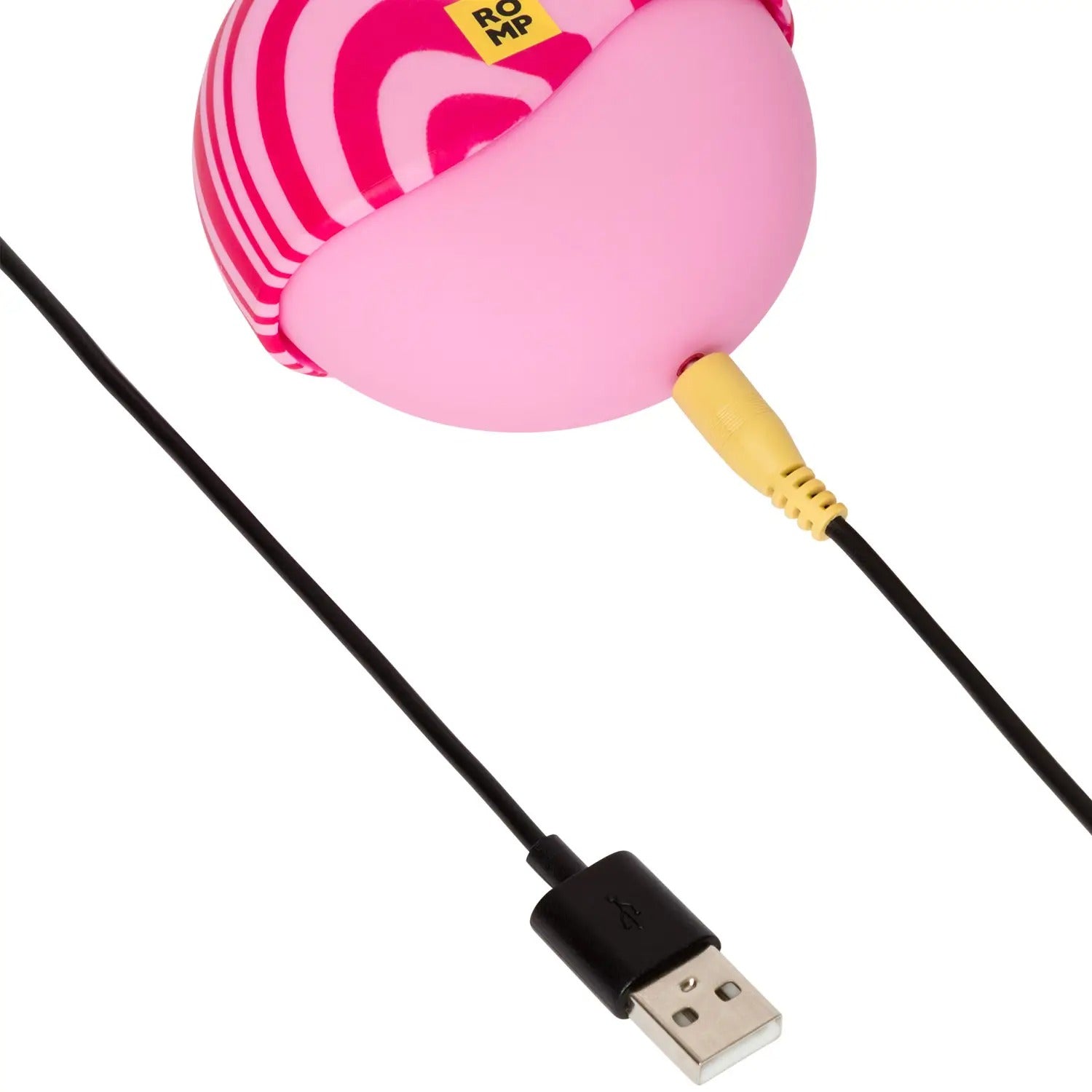 ROMP Spin clitoral stimulator placed next to its USB magnetic charging cable.