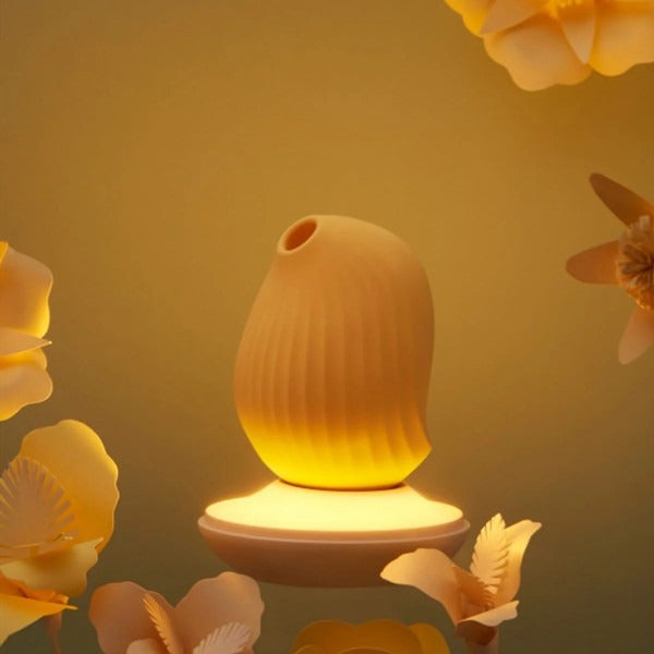 Cuddly Bird glowing beneath a clear dome cover beside blue unit on tabletop.